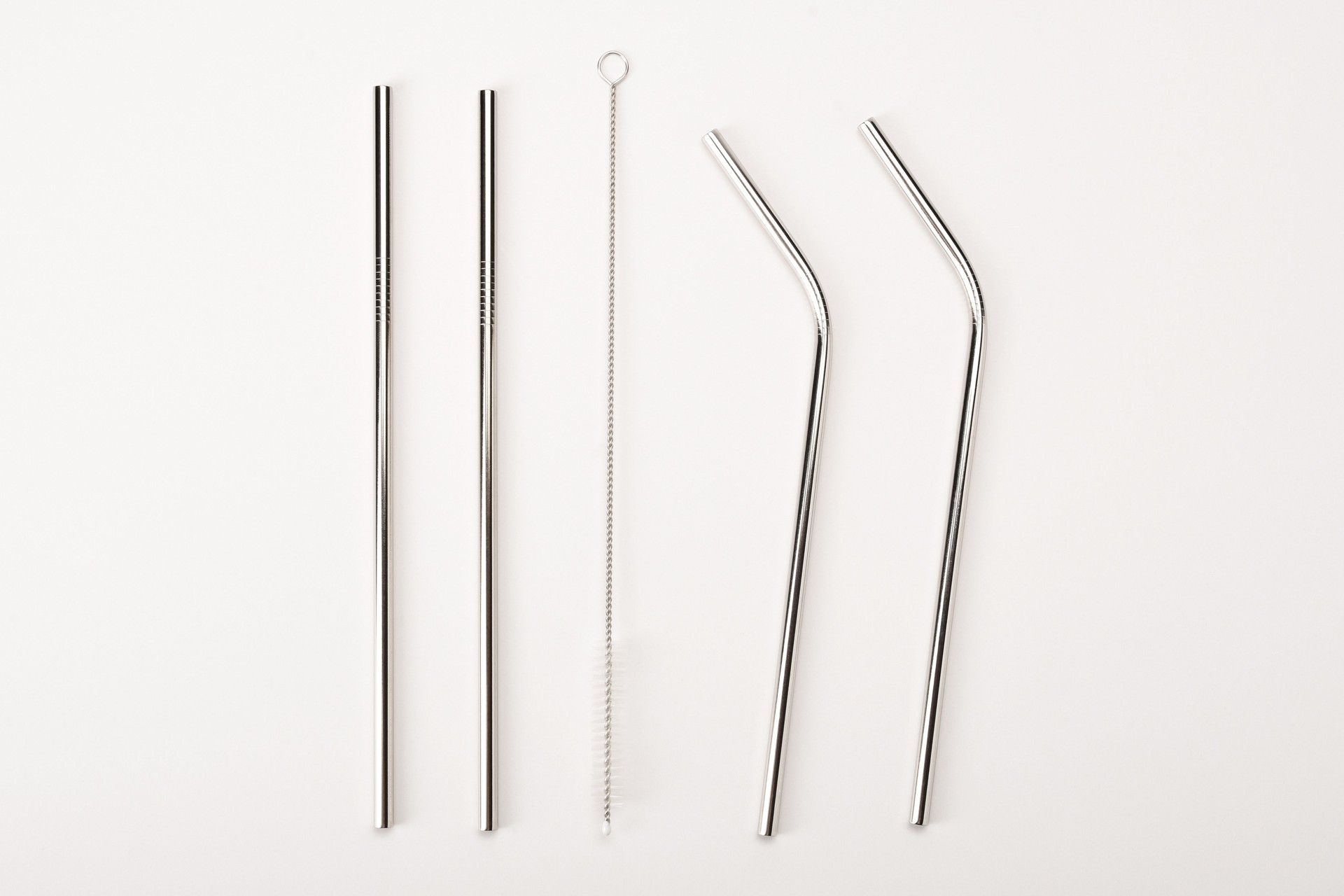 Stainless steel reusable drinking straw set, metallic pipette on the white background